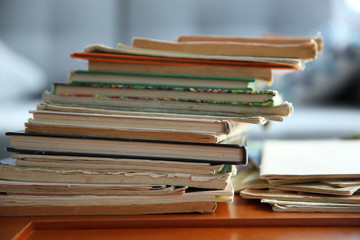 Pile of old books on brown table in the room