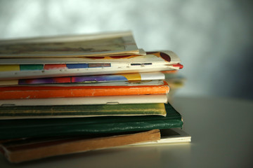 Pile of books on the table against grey wall, close up