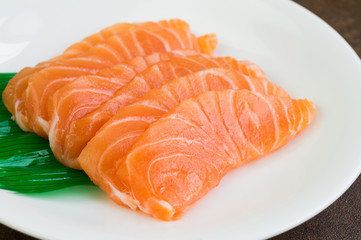 Sliced raw salmon on white plate