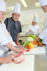 Chef watching student tie joint of meat