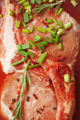 Marinating meat with spices on wooden table