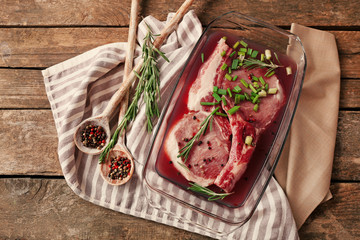 Marinating meat with spices on wooden table