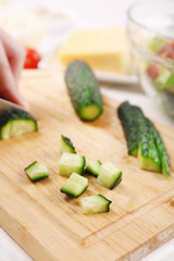 Female hands cutting vegetables for salad, at kitchen