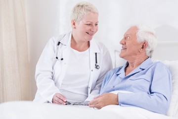 Nurse smiling to her senior patient