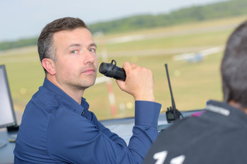 Man in control tower talking into radio receiver