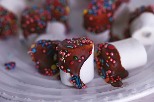 Tasty marshmallows with chocolate on plate, close up