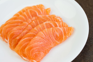 Sliced raw salmon on white plate