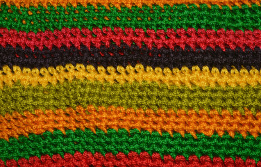 Red, yellow, green, black, orange knitted texture, background