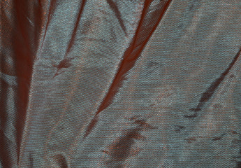 Iridescent fabric chameleon in orange, brown and purple colors, texture, background