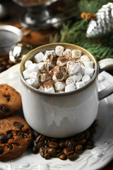 Mug of hot chocolate with marshmallows, fir tree branch on wooden background