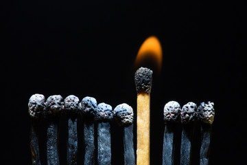 Row of burned matches with single fired up.