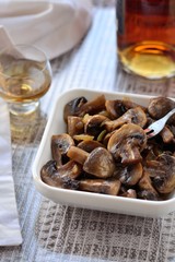 Baked mushrooms in olive oil with onion, lemon juice and brandy