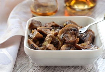 Baked mushrooms in olive oil with onion, lemon juice and brandy