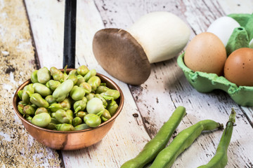 Fresh beans, mushrooms and eggs on  wooden table