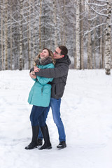 Fototapeta na wymiar Young beautiful couple walking in winter forest