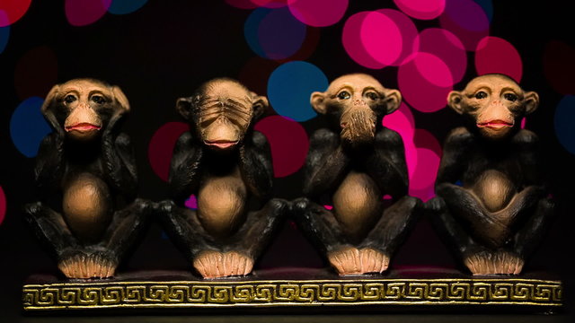 Figure four symbolic monkeys on bokeh background.