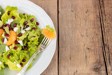 Healthy salad with pomegranate and mandarins