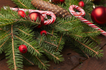 Christmas tree branch, candy, cones, balls on the background of