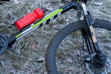 the black mountain bicycle on a grass with hoarfrost