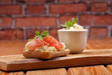 Sandwich with white cottage cheese and ham on wooden background