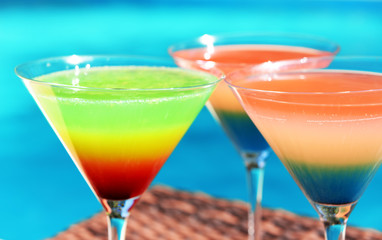 Cocktails on swimming pool background