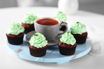 Beautiful chocolate cupcakes and cup of tea,  on table