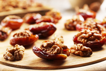 Walnut, date fruit on wooden table, close-up