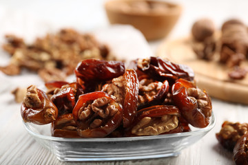Walnut and date fruit on wooden table, close-up