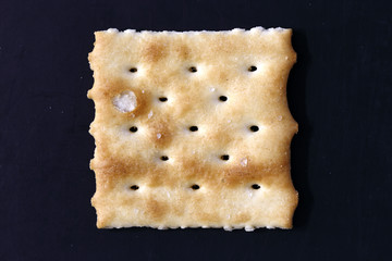 Cracker close-up on black background. View from above