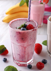 Milkshakes with berries on light wooden background, close-up