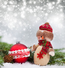 Holiday background with Christmas ball and snowman figurine