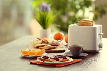 Served table for breakfast with toast, coffee and fruit, on blurred background
