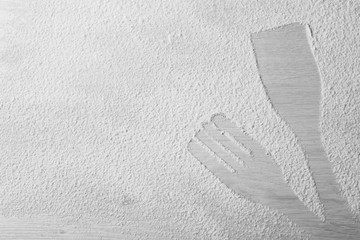 Flour sprinkled around kitchen utensils on light background