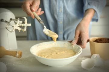 Obraz na płótnie Canvas Woman is mixing dough with a spoon