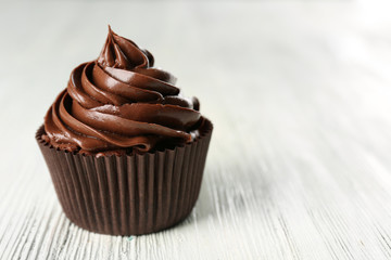 Chocolate cupcake on light wooden background