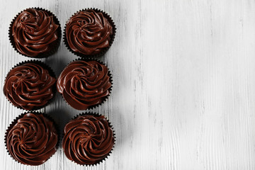 Chocolate cupcakes on light wooden background