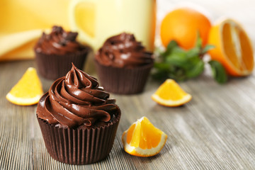 Chocolate cupcakes served with orange on a table