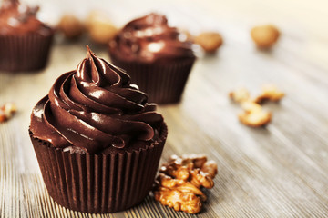 Chocolate cupcakes with nuts on wooden table