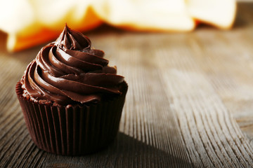 Chocolate cupcake served with a drink on wooden table