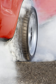 race car burns rubber off its tires in preparation for the race