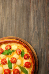 Pizza Margherita with arugula on wooden background