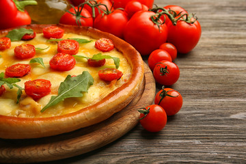 Pizza Margherita with arugula, tomatoes   wooden table