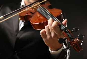 Musician play violin on black background, close up