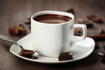Cacao with chocolate and cinnamon on wooden table