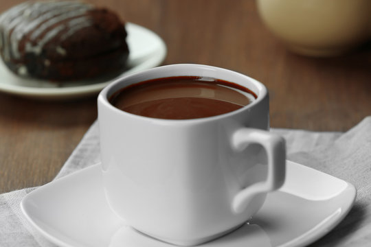 Cup of cacao with biscuit on wooden table