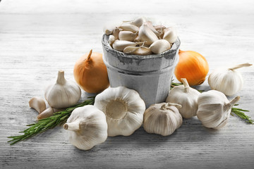Composition of garlic, onion and rosemary on wooden table