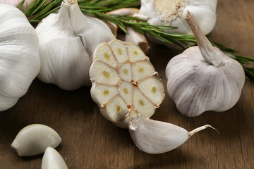 Composition of garlic and rosemary on wooden background, close up