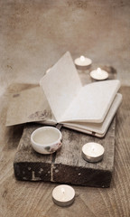 Artwork in vintage style, china tea, notebook, candles