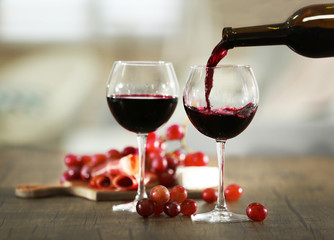 Pouring red wine from bottle into the wineglass