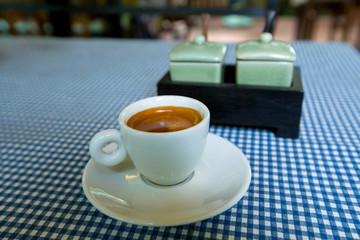 A cup of espresso on a table.